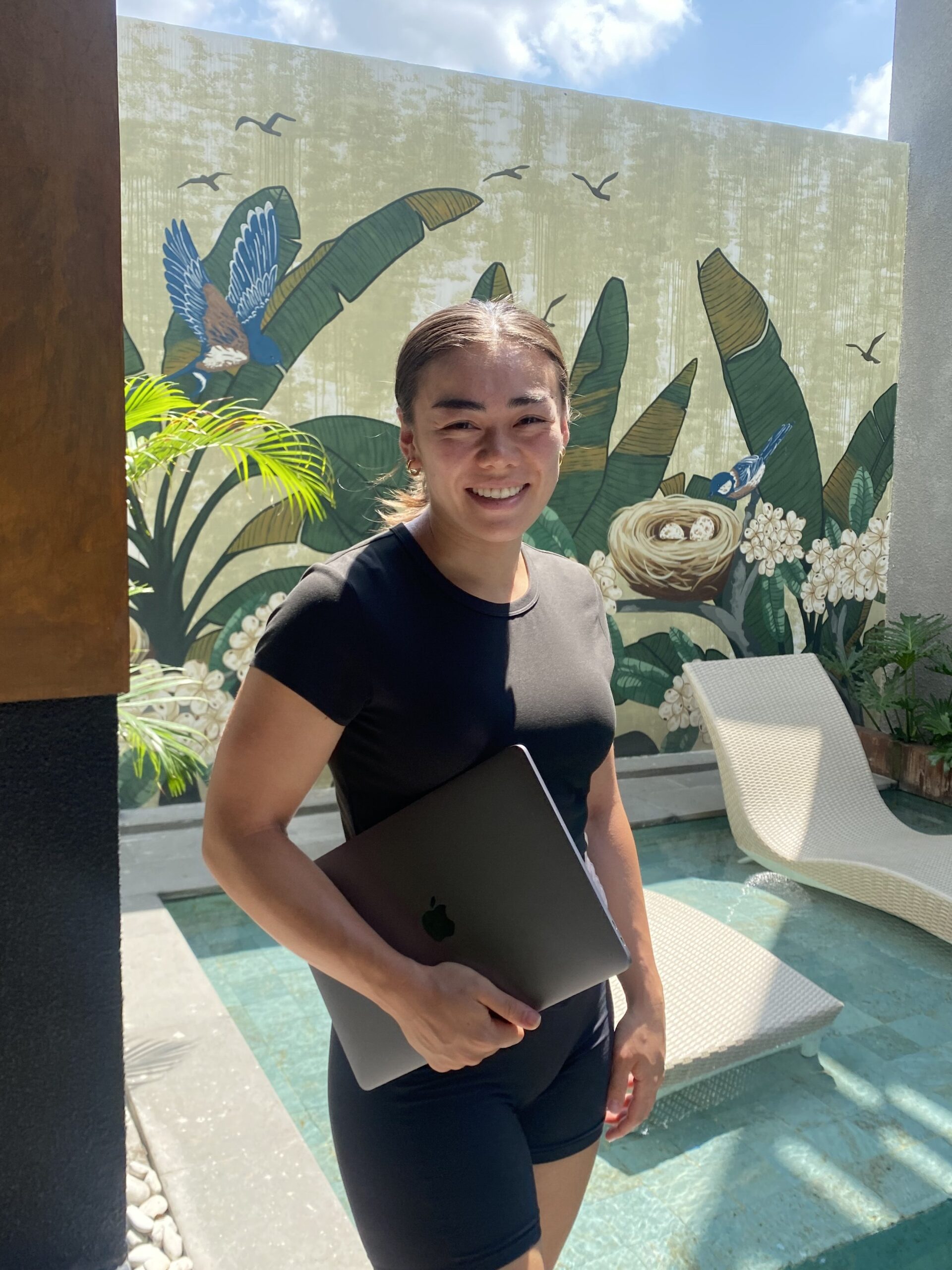 Anna standing outdoors with laptop, showcasing professional flexibility and remote work capabilities